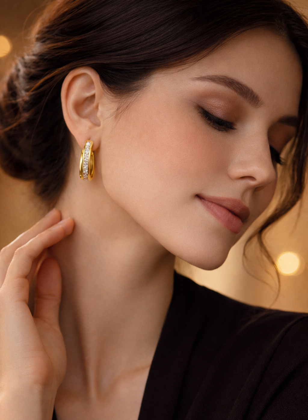 Close-up of a woman wearing gold earrings with a warm, blurred background