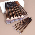Set of makeup brushes with brown and black handles on a beige background