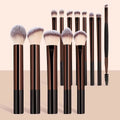 Set of makeup brushes with black and brown handles on a beige background
