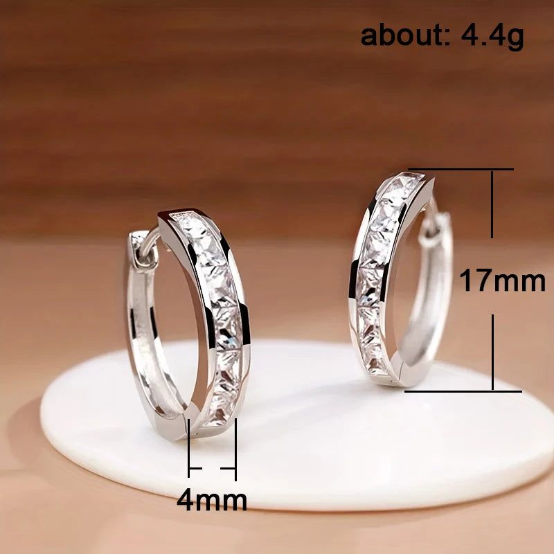Silver hoop earrings on a white stand with measurements indicated.