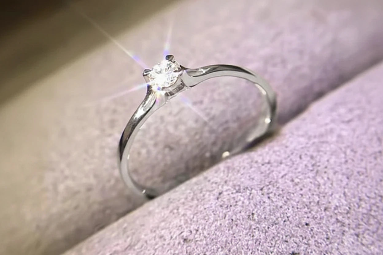 Silver ring with a diamond on a soft fabric background